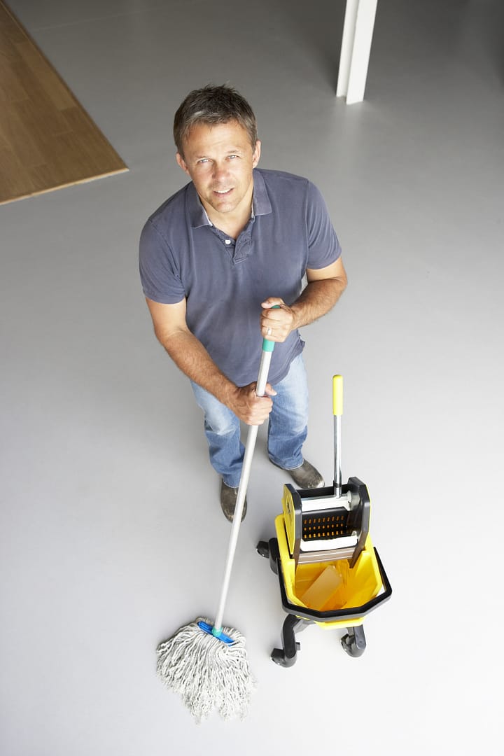 Office cleaner mopping a floor