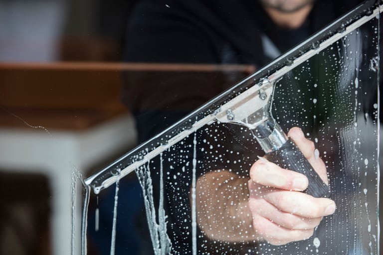 a man cleaning a window with a squeegee