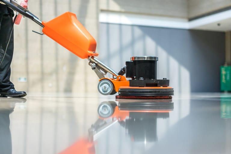 orange floor machine buffing a floor
